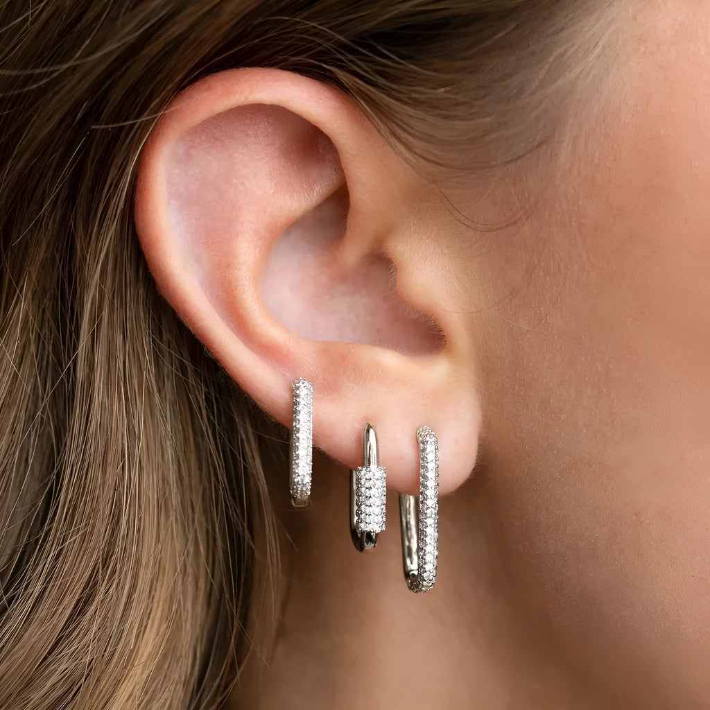 Three geometric ear clips with micro-inlaid zircon stones on copper, showing gold and white gold colour options
