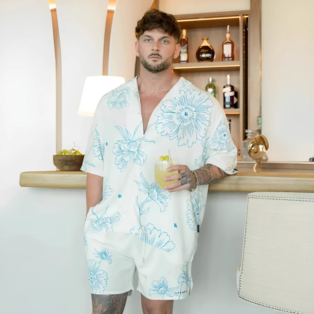 Man wearing a loose, short-sleeve printed cardigan top in a floral pattern.