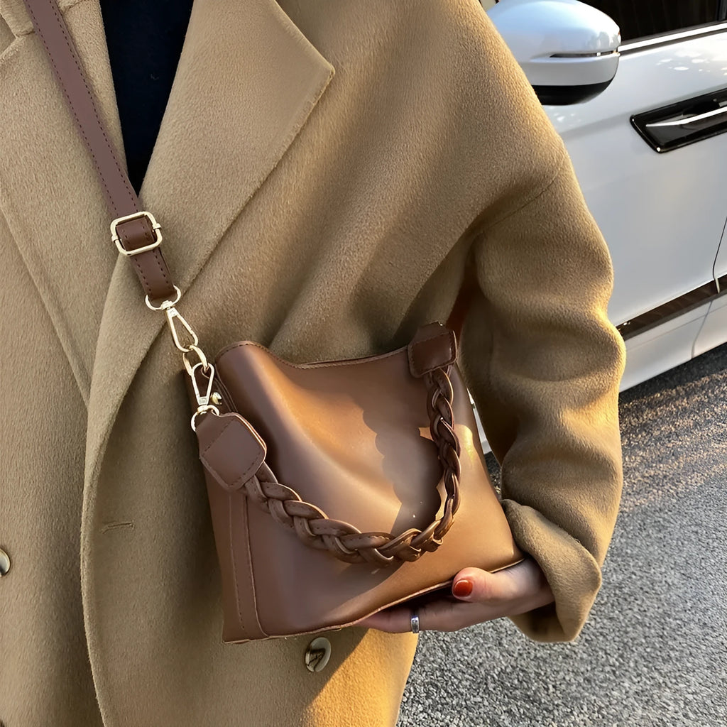 Unisex khaki PU leather crossbody bucket bag with woven texture and one shoulder strap.