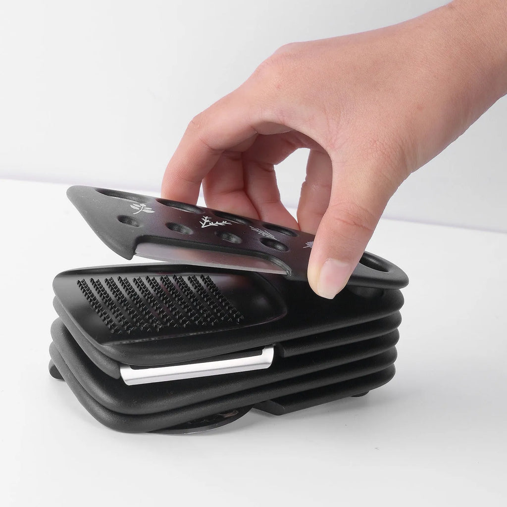 Six stainless steel kitchen gadgets and a brush stored in a modern simple colour box.