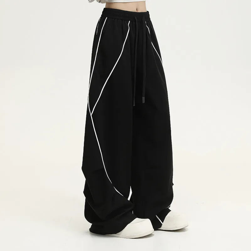 Black pleated wide-leg hip hop trousers with a striped pattern on a mid waist.