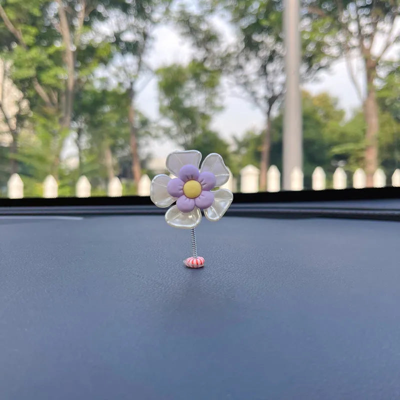 Blue plastic swing-shaped car decoration with a smiling face, hanging from a loop.