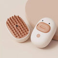 White and yellow rechargeable steam brush for grooming dogs and cats on a table.
