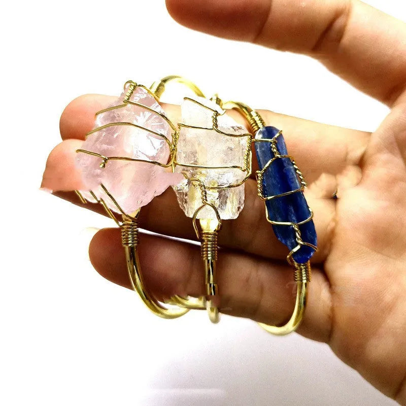 Explosive design natural crystal rough stone bracelet with gold winding on a wrist.