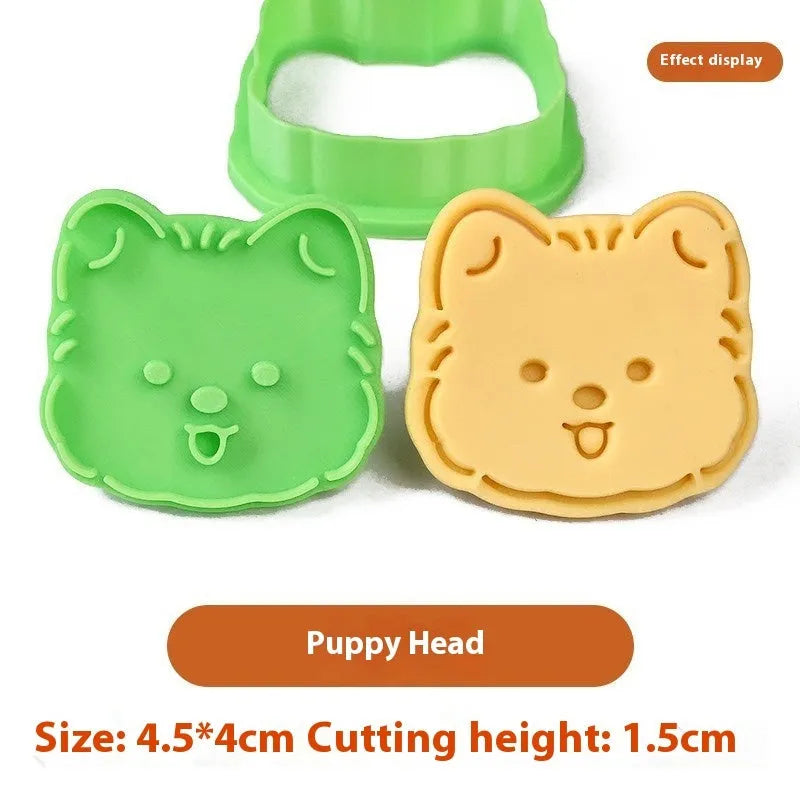 Three-dimensional plastic biscuit mold showing cartoon puppy designs including birthday hat and swimming ring motifs
