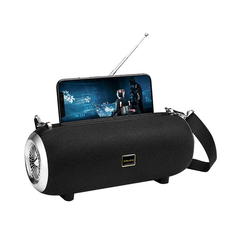 F666 Mini portable Bluetooth speaker with fabric mesh finish, shoulder strap, and standing next to a mobile phone.