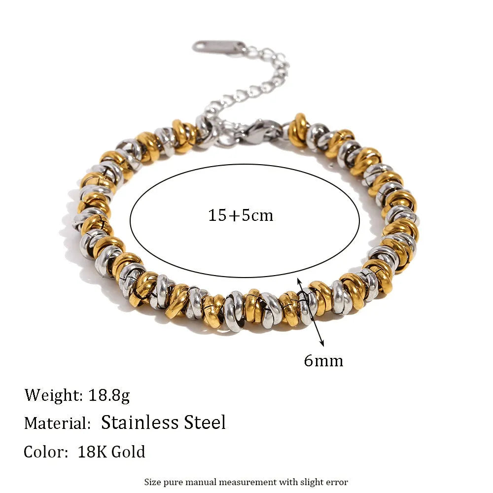 Gold electroplated geometric jewellery set with earrings, bracelet and necklace on white background