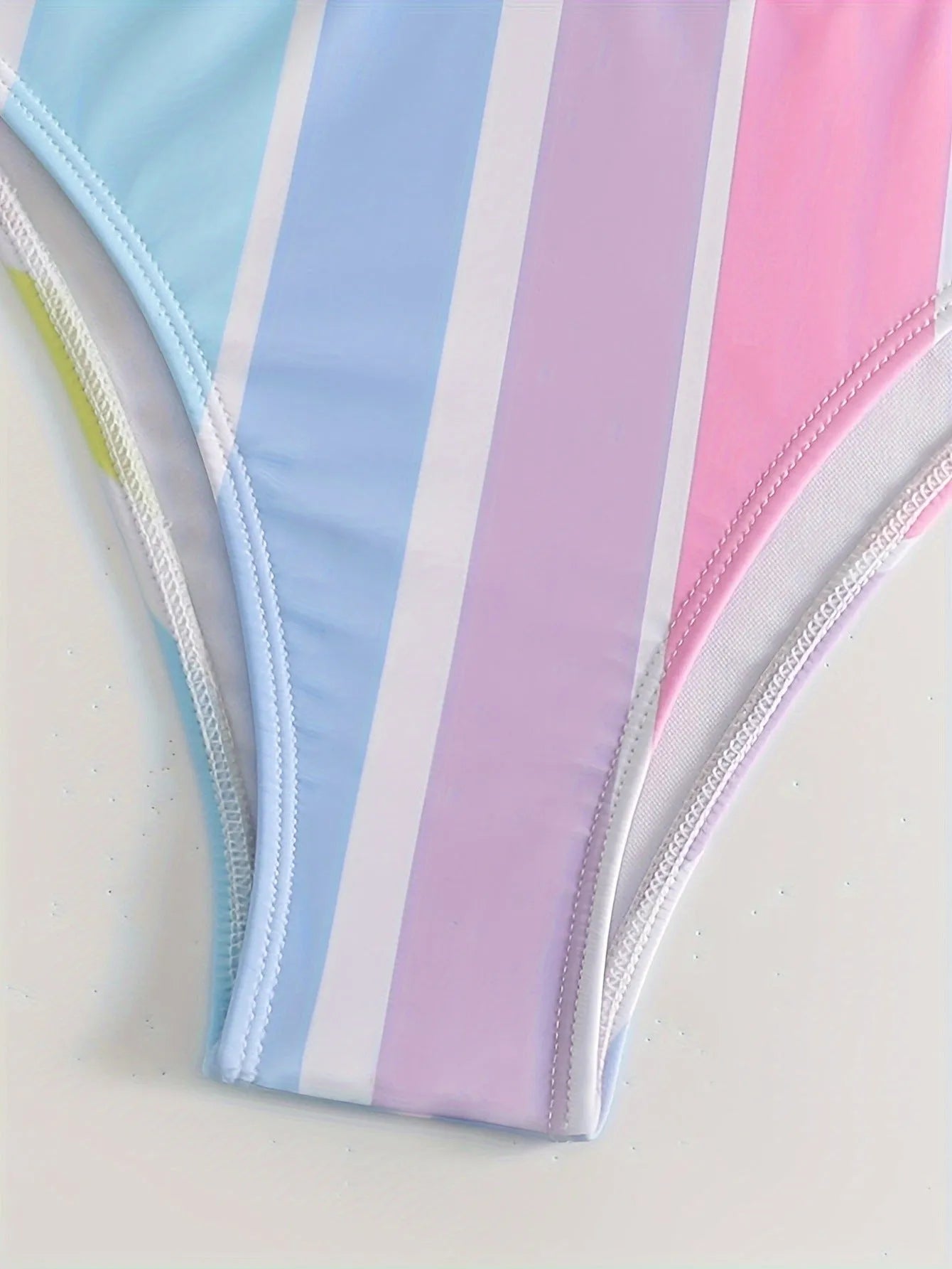 Women's striped two-piece bikini set for swimming and sports on a neutral background.