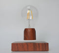 Magnetic levitation light bulb with imitation wood base on table.