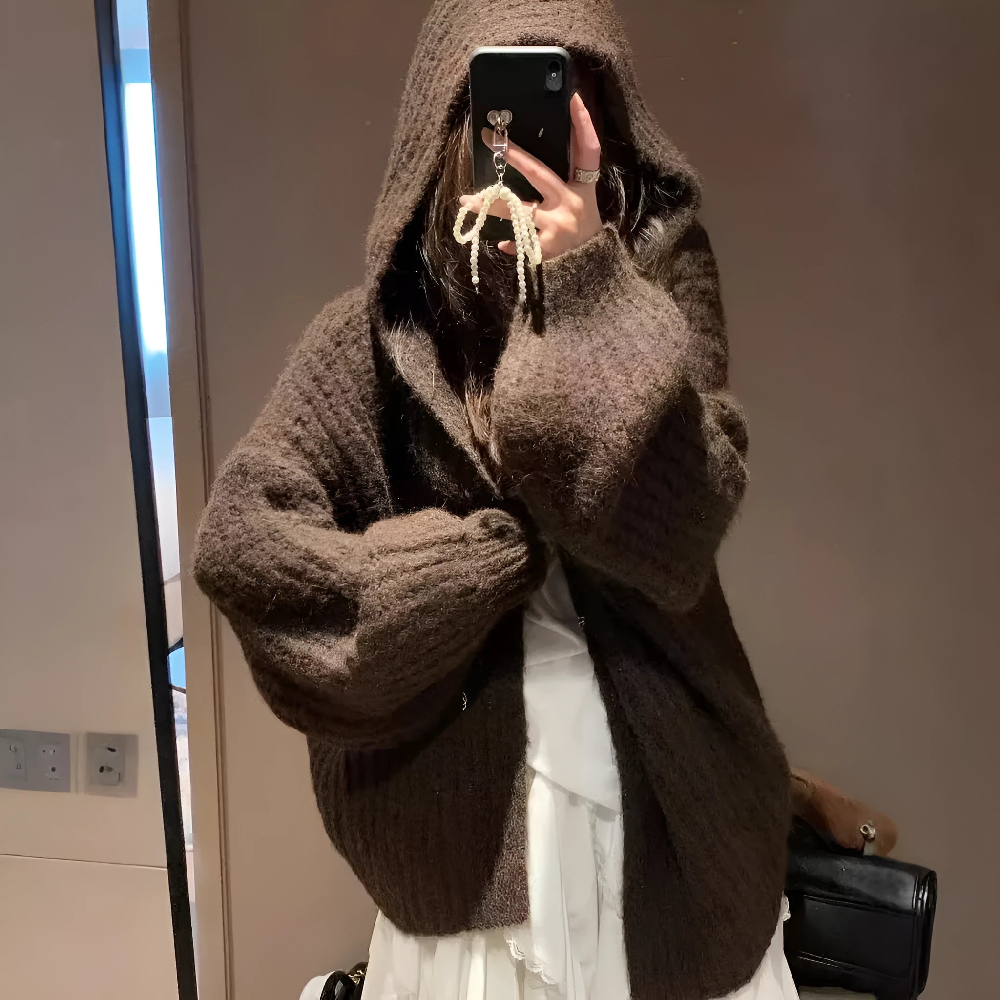 Brown women's loose-fit hooded sweater cardigan with regular sleeves on a hanger