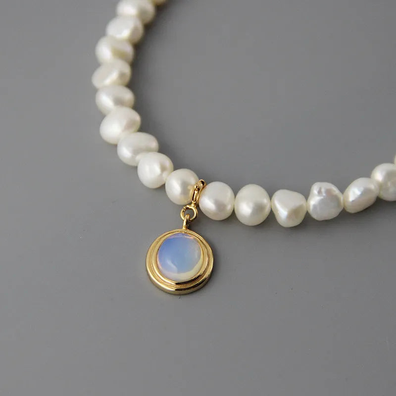 Sterling silver geometric necklace with irregular pearl pendant on adjustable chain.