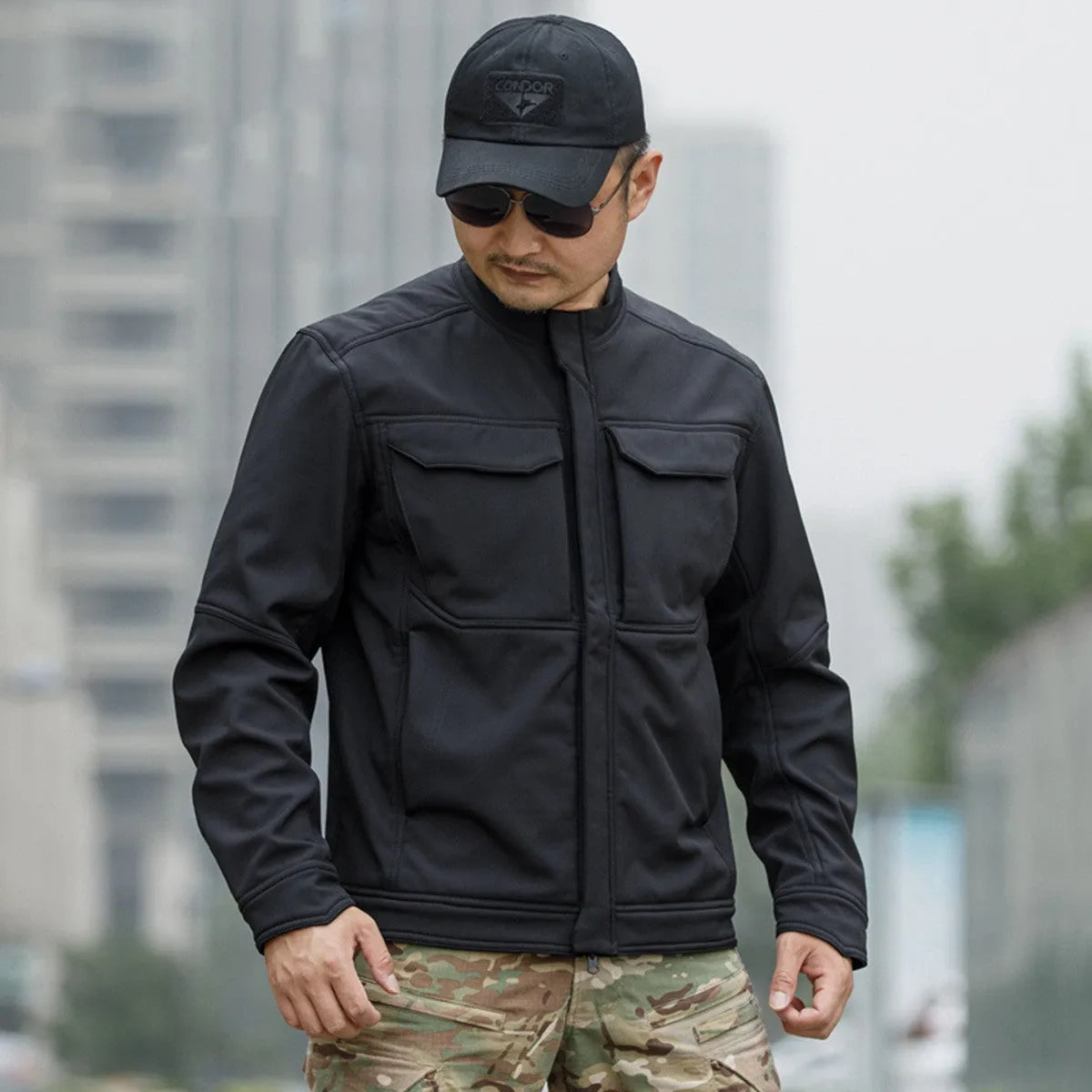 Bone Frog Peak Breaker soft shell tactical jacket in black, shown in outdoor setting.