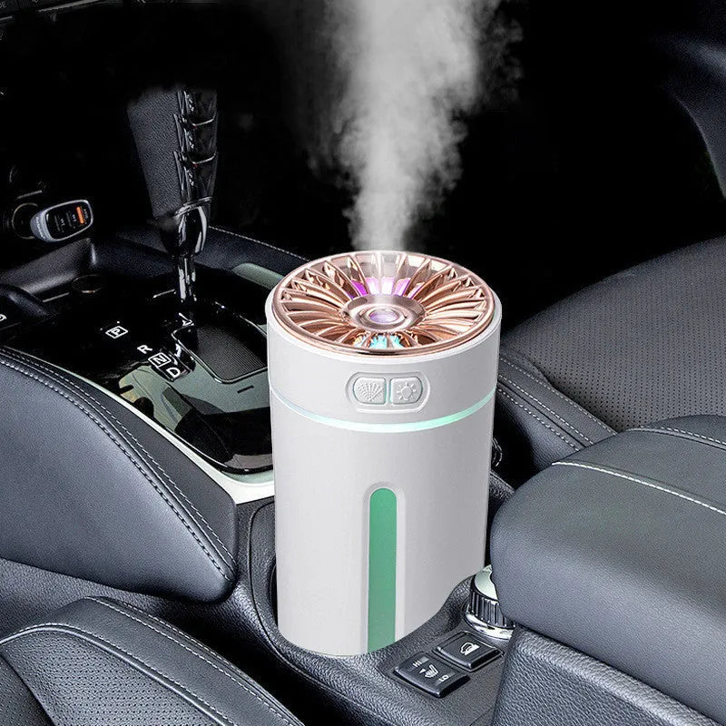 Black and white portable USB rechargeable humidifier with colourful LED lights on a car cup holder.