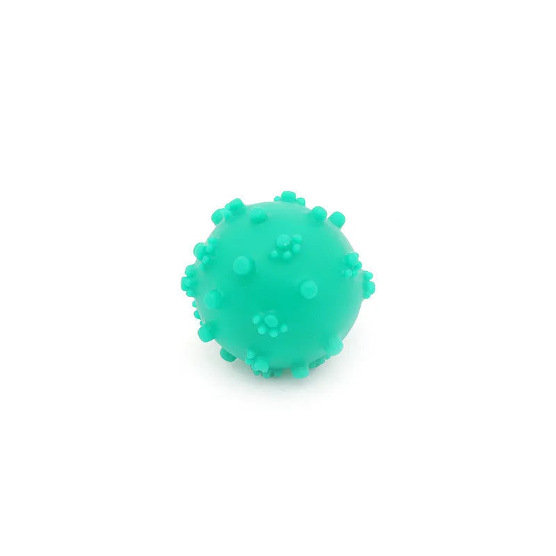 Bright blue, green, pink, and yellow spiked dog balls with paw print dimples on a white background.