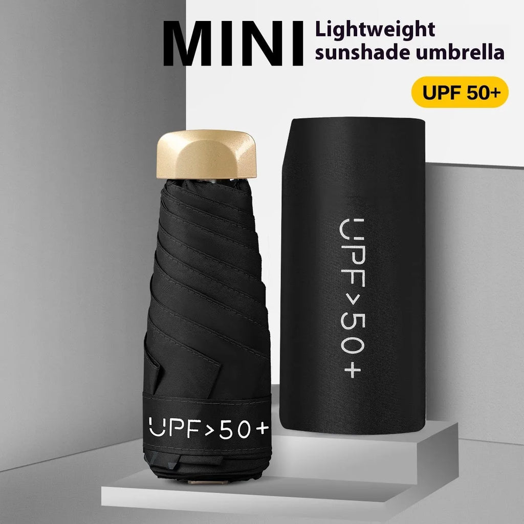Closed black five-fold mini pocket sun umbrella with rubber handle showing compact size.