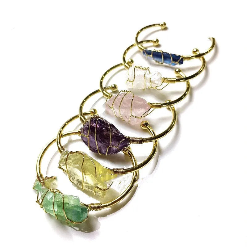 Explosive design natural crystal rough stone bracelet with gold winding on a wrist.