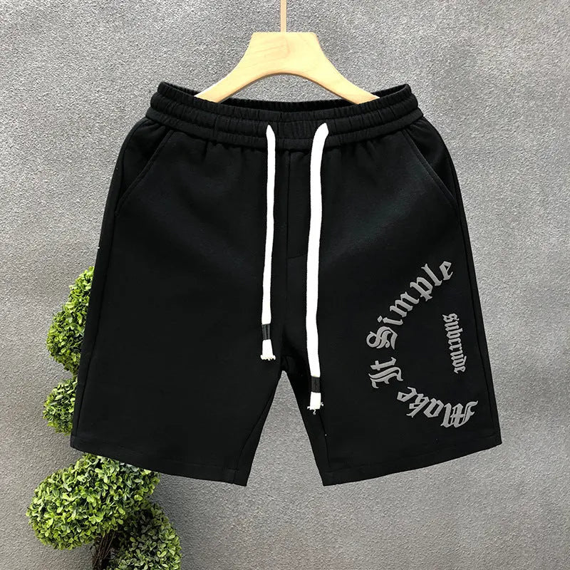Printed cropped polyester sports pants in black for teenage men, side view showing cropped leg length