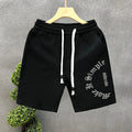 Printed cropped polyester sports pants in black for teenage men, side view showing cropped leg length
