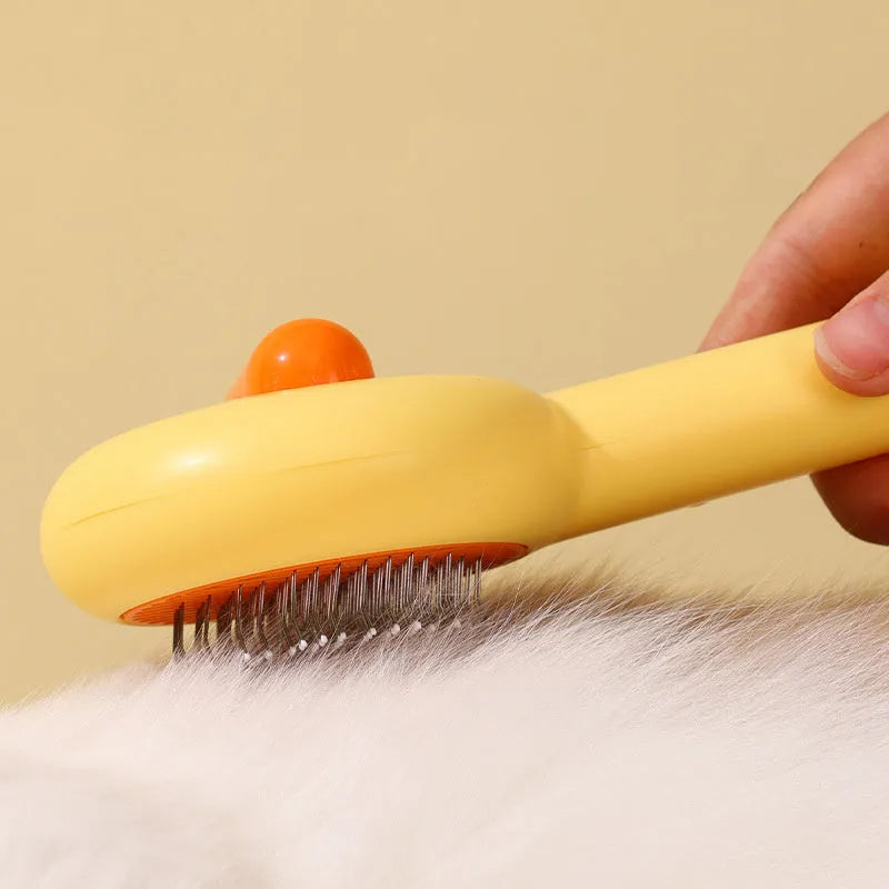 Small yellow duck-shaped pet grooming comb with needle teeth for cat and dog hair removal