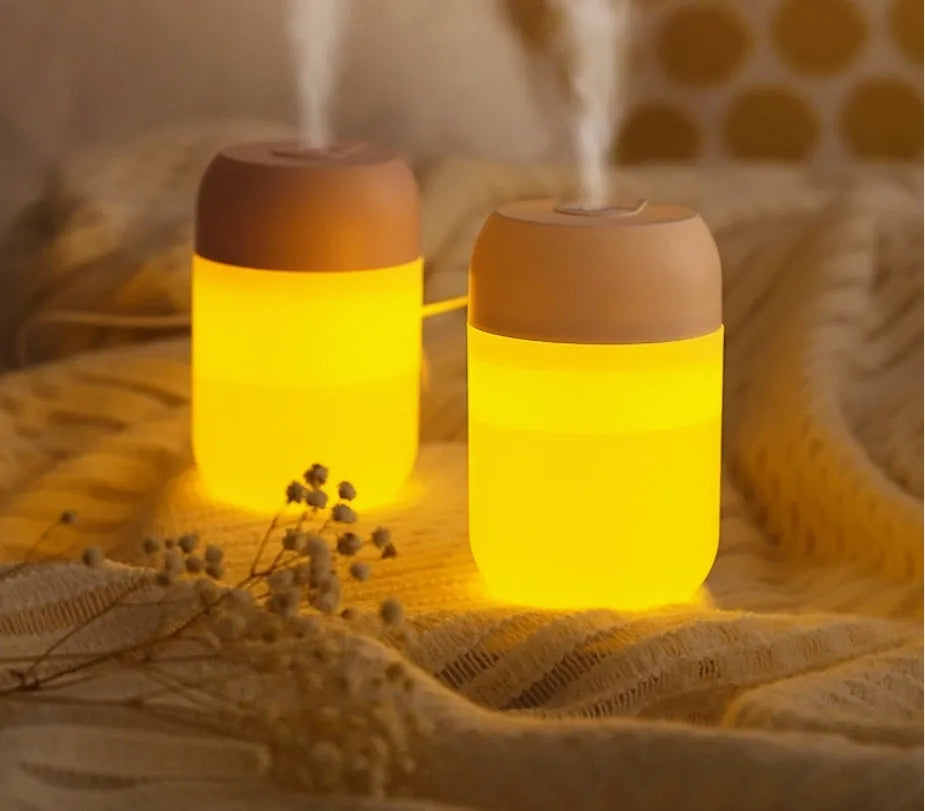 White cylindrical USB-powered small humidifier with aromatherapy function on wooden desk