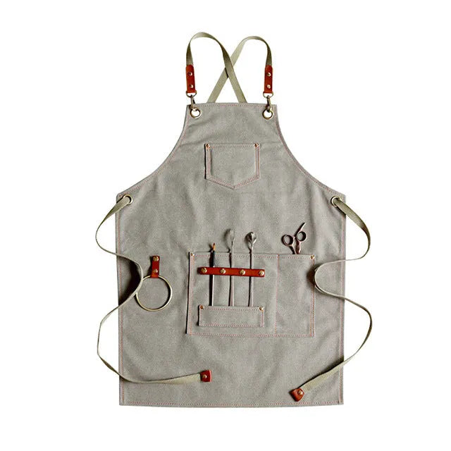 Canvas apron with cross-back straps in camel colour, shown laid flat