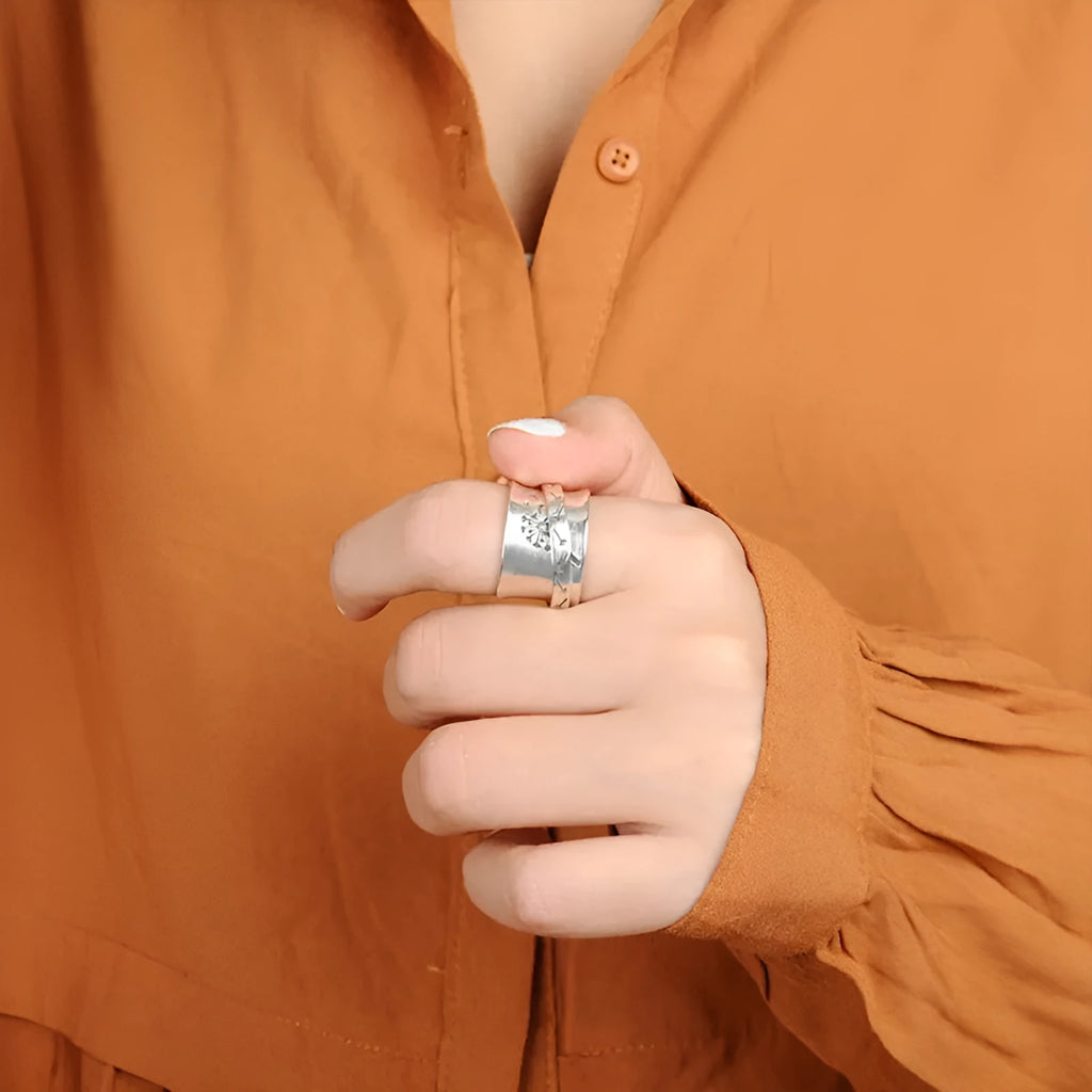 Silver rotatable floral fashion ring showing adjustable flower element on band
