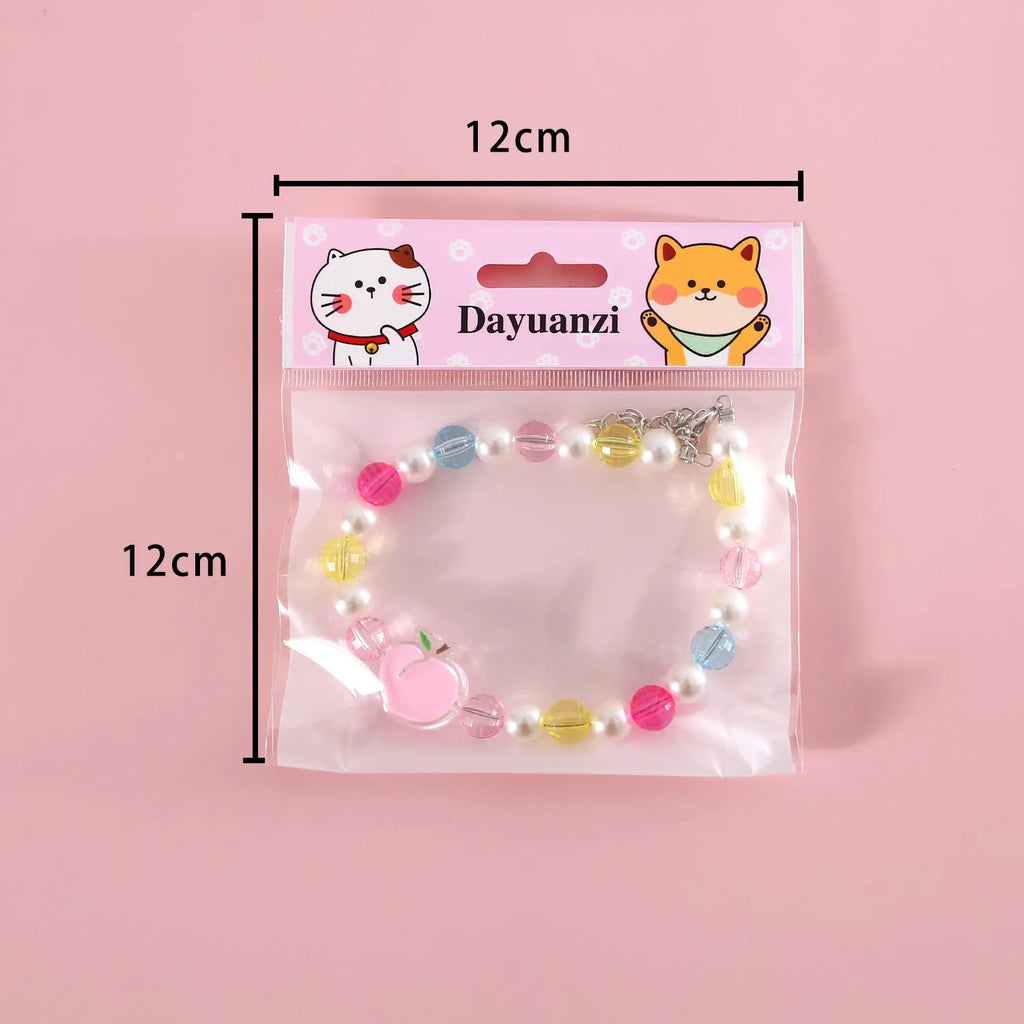 Adjustable colourful bead cat necklace in small flower, rainbow, or peach design on a white background.