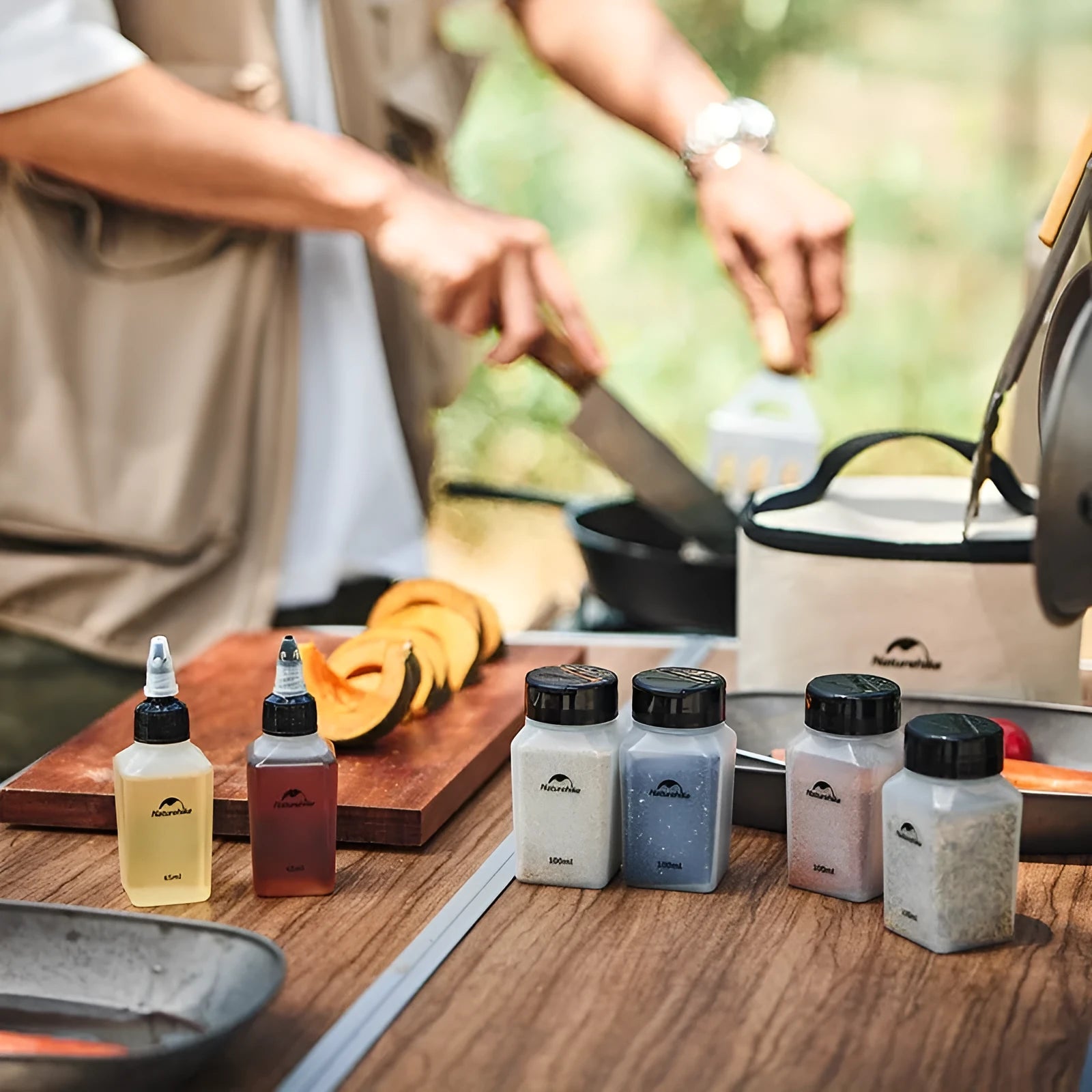 Set of six white portable seasoning bottles with black lids for outdoor picnics and camping.