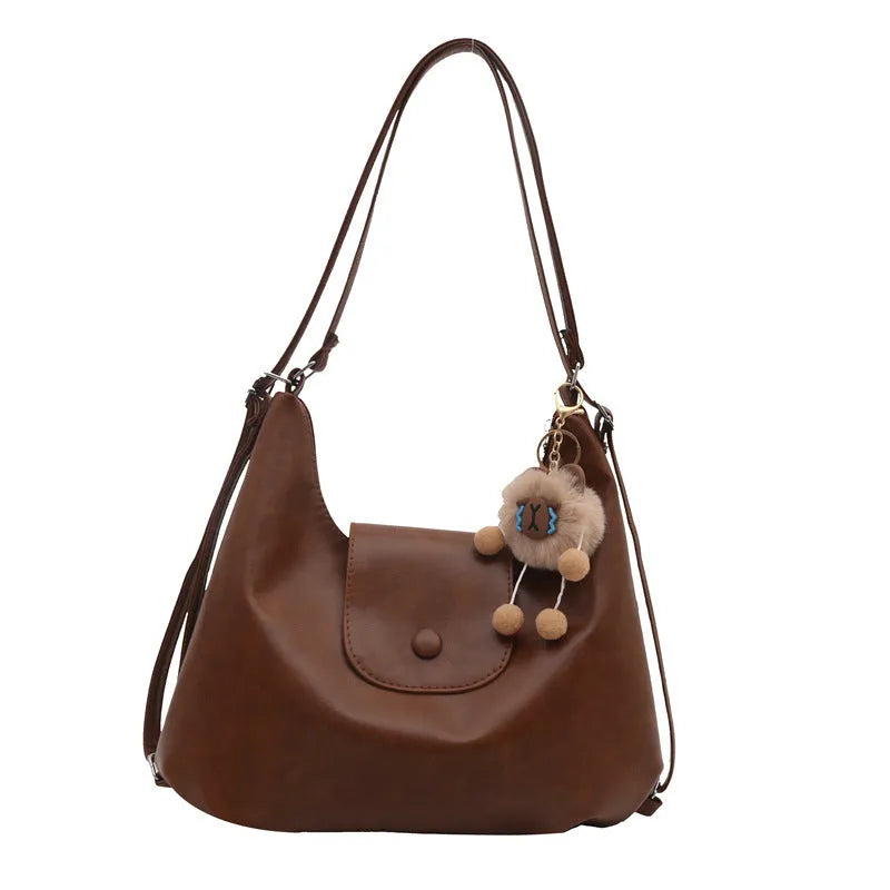 Textured PU leather commuter shoulder backpack in horizontal square shape with single strap and mobile phone compartment