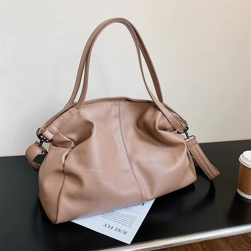 Large soft surface messenger bag showing horizontal square shape with adjustable shoulder strap and zip opening