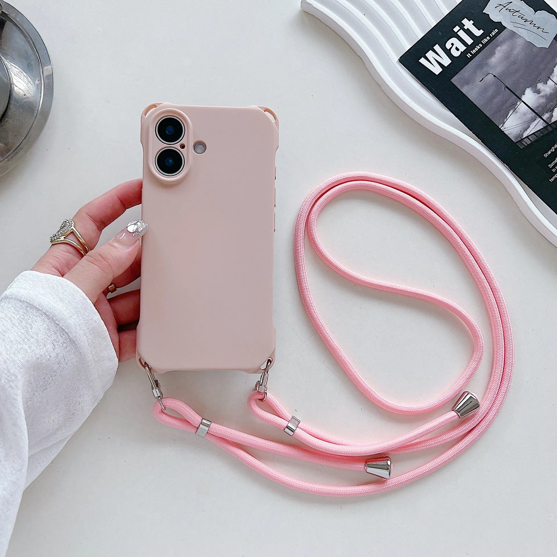 Four-corner cross lanyard liquid silicone phone case for Apple iPhone 16 in antique white with matching lanyard