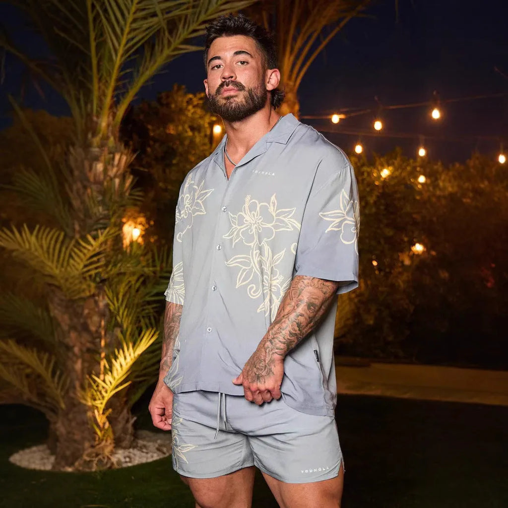 Man wearing a loose, short-sleeve printed cardigan top in a floral pattern.