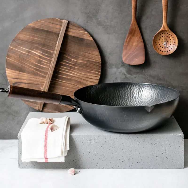 Traditional black iron wok with long wooden handle measuring 32cm diameter