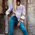 Lilac plaid print loose long sleeve sweater with ribbed cuffs and hem on a hanger.