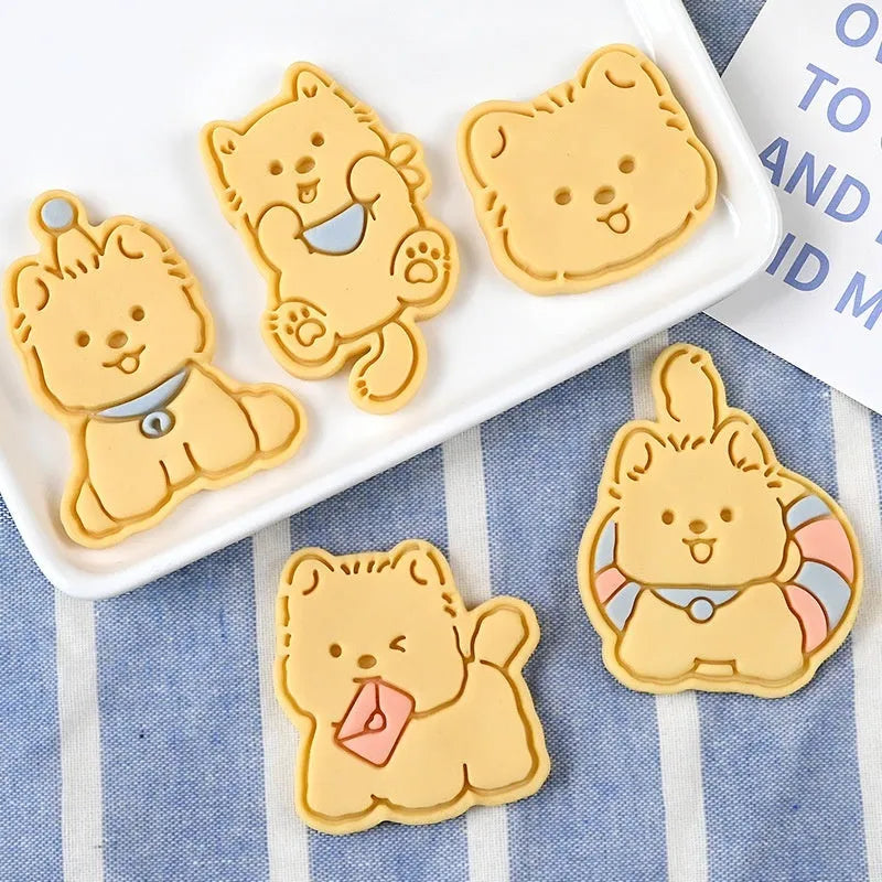 Three-dimensional plastic biscuit mold showing cartoon puppy designs including birthday hat and swimming ring motifs