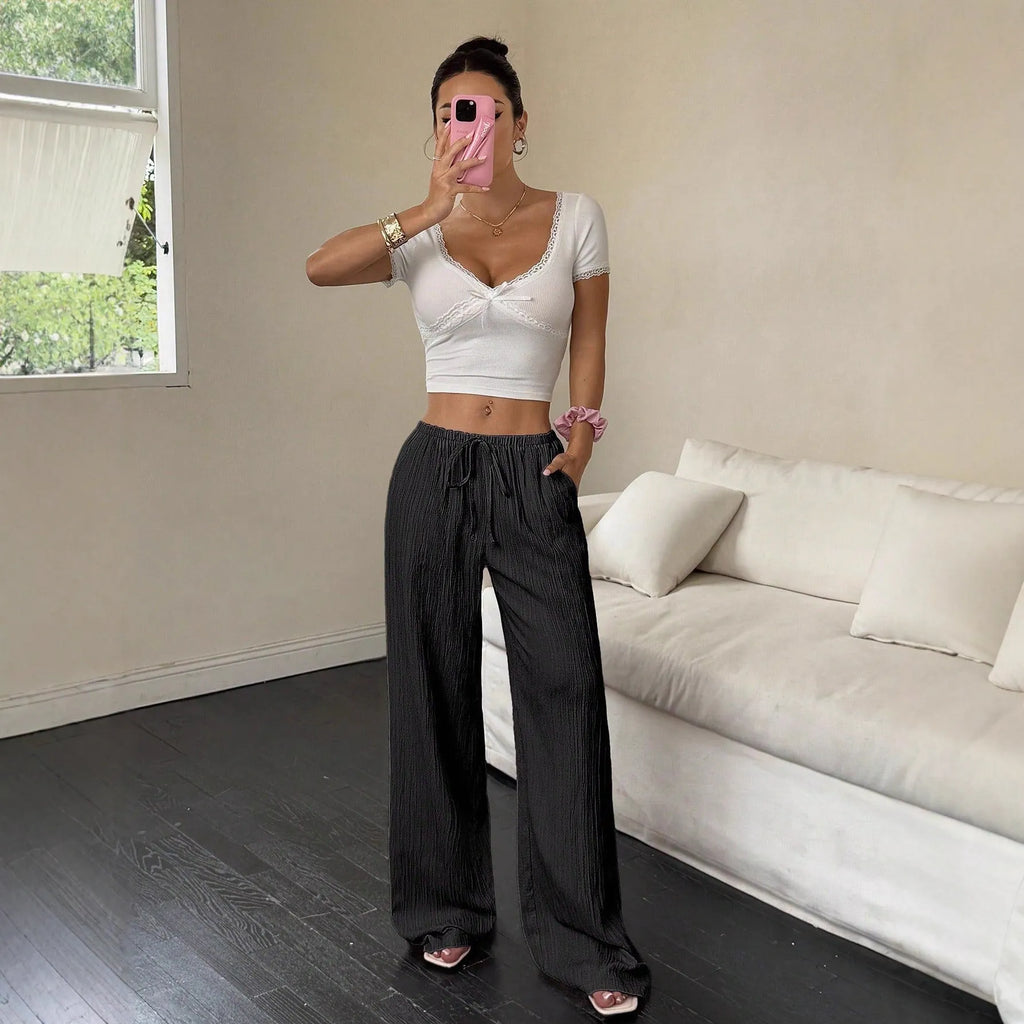 Black wide leg women's trousers with a lace-up waist trimming detail on a mid waist.
