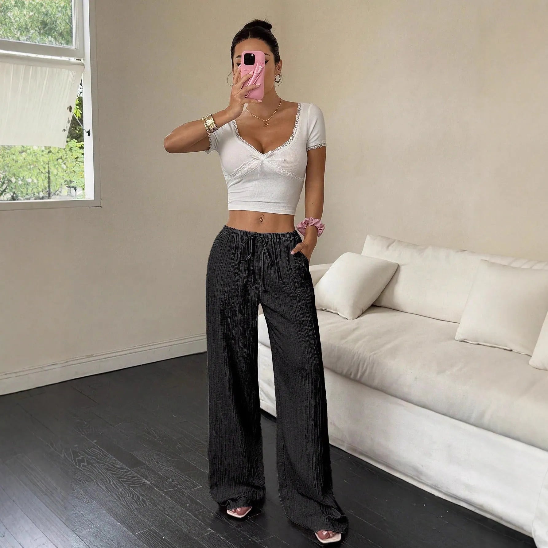 Black wide leg women's trousers with a lace-up waist trimming detail on a mid waist.
