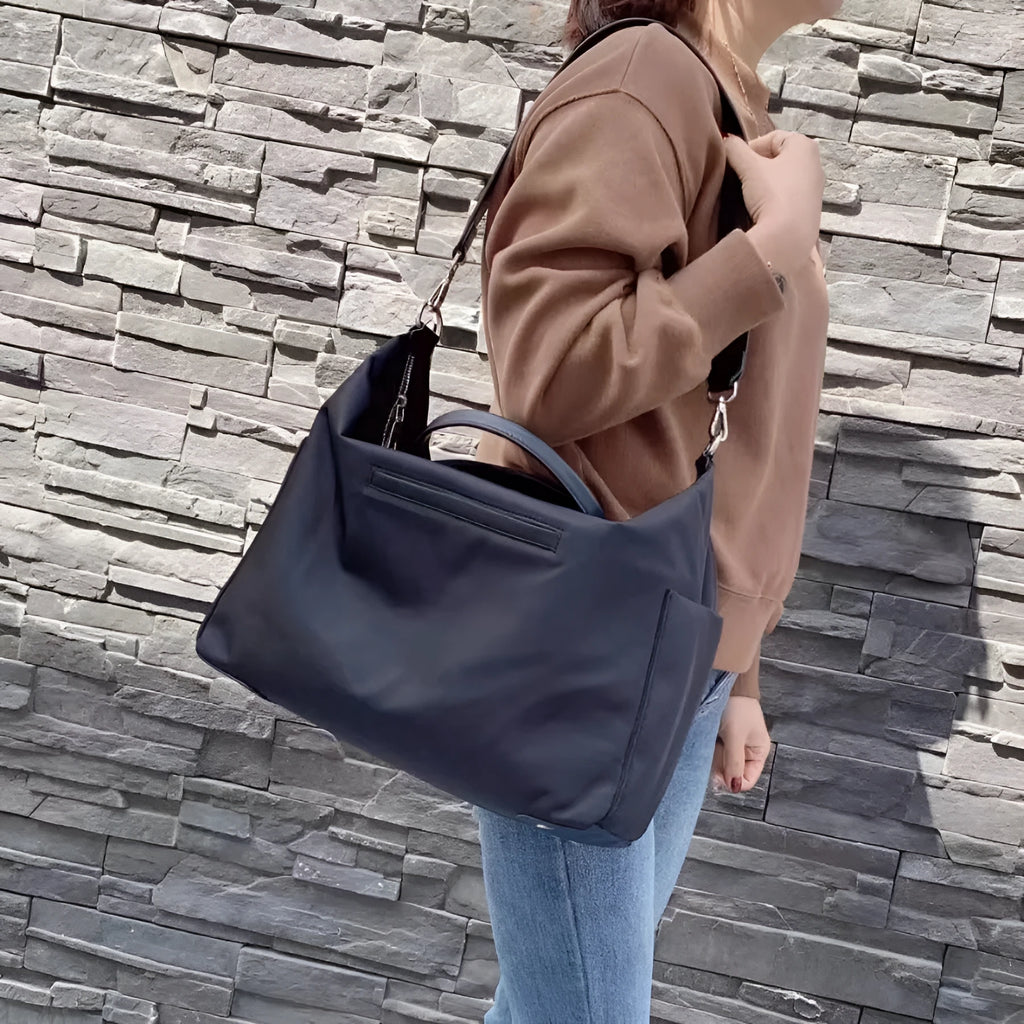 Nylon waterproof shoulder bag in black or light khaki colour measuring 35cm wide