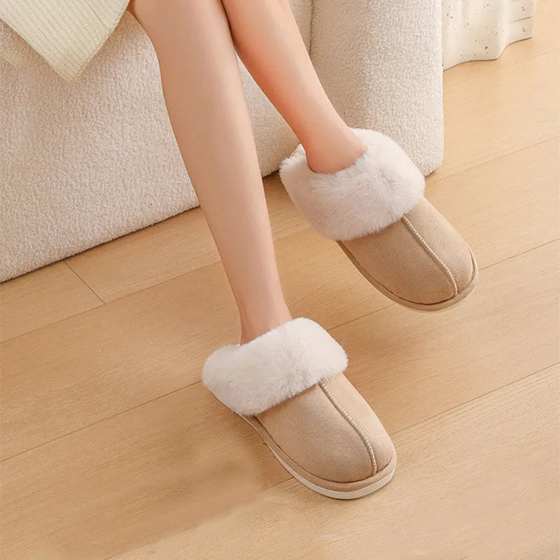 Brown plush indoor slippers with round toe, decorative stitching, and a light-coloured anti-slip sole.