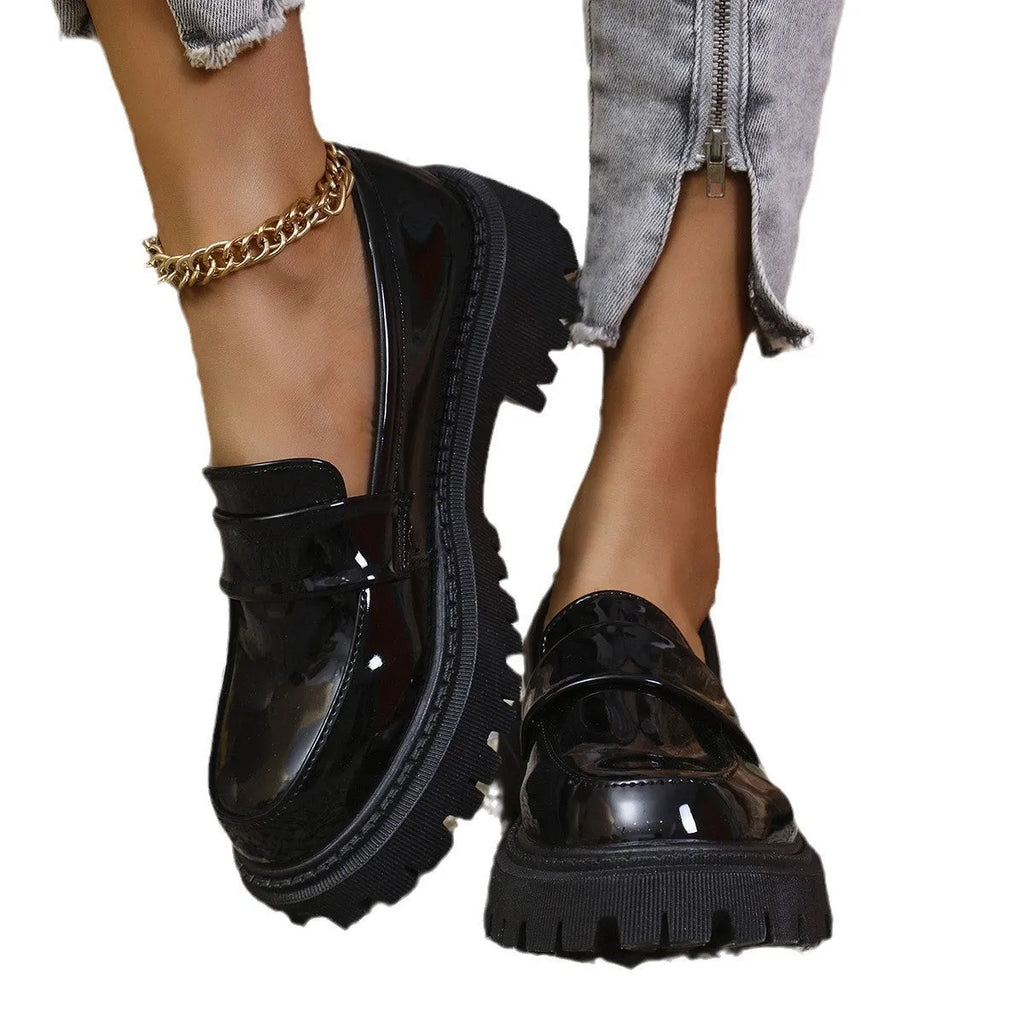 Plus size black slip-on loafers with chunky platform heel on a solid colour background