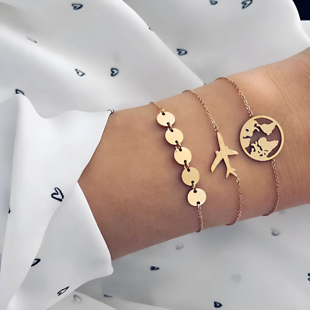 Three bohemian-style bracelets with heart-shaped aircraft map charms in electroplated alloy