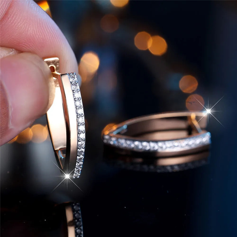 Geometric V-shaped women's earrings in champagne gold with white diamond accents on a copper base.