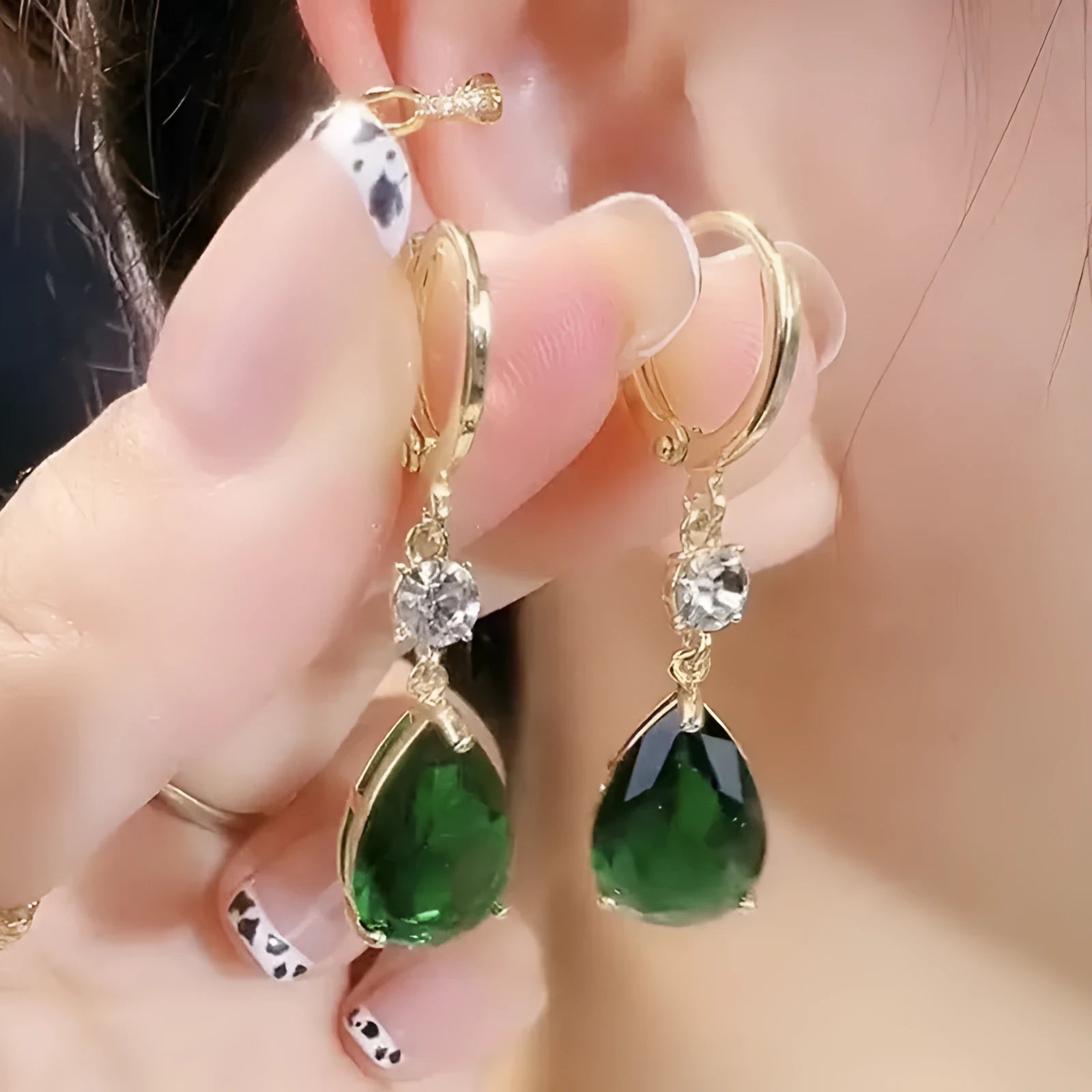 Geometric green teardrop alloy earrings on a plain background