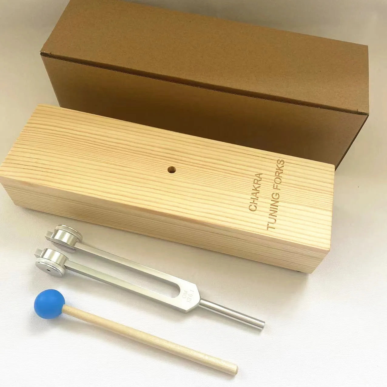 Aluminium alloy 432Hz tuning fork with speaker on kraft paper box background