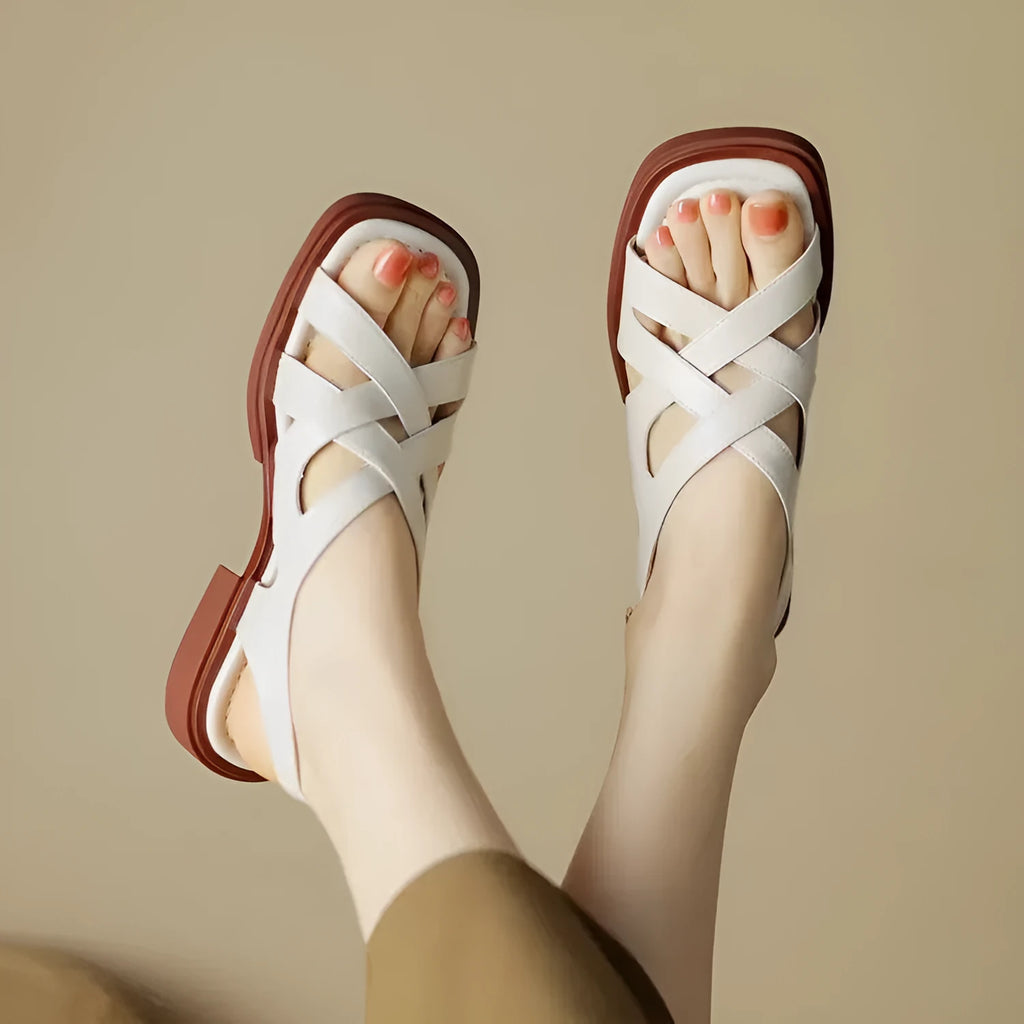 Women's glossy black patent leather beach sandals with square toe and cross-band strap.