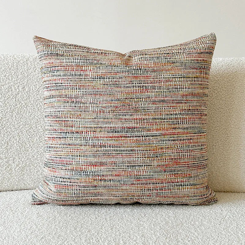 Amber paisley patterned jacquard sofa cushion cover on a sofa, showing textured fabric and plant motif.