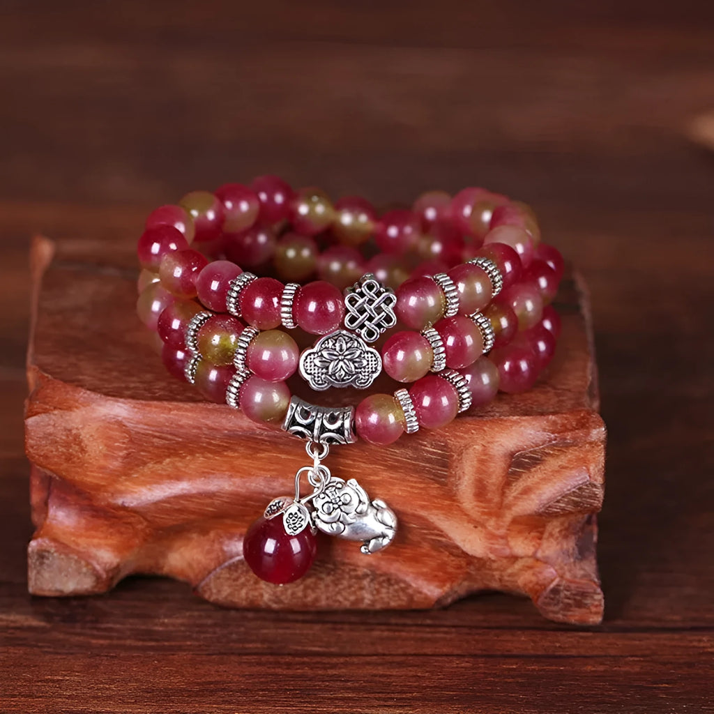 Handmade natural watermelon crystal bracelet with Chinese knots, shown in geometric national style.