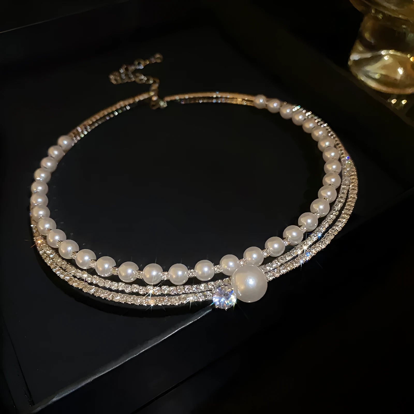 Silver curved geometric alloy necklace resting to show its clavicle chain design.