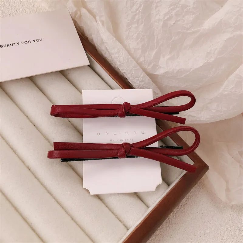 Wine red leather bow hair barrettes showing handcrafted details and bow design
