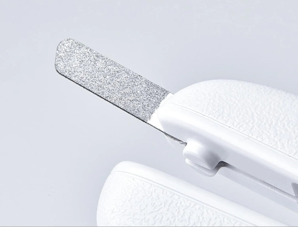 White LED pet nail clippers with transparent guard, triangular blade, and anti-slip handle next to a filing tool.